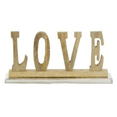 the word love spelled with wooden letters on a white shelf against a white background photo