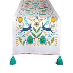 an embroidered table runner with tassels on it