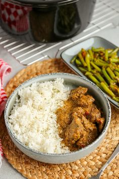 a bowl filled with rice and meat next to green beans