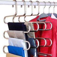 a rack with clothes hanging from it's sides and some folded ones on the hangers