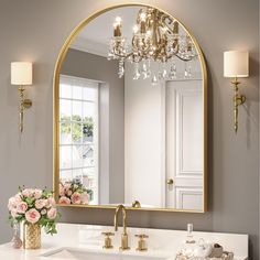 a bathroom sink with a large mirror above it and flowers in the vase on the counter