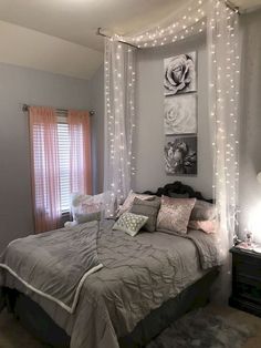 a bedroom decorated in gray and white with string lights on the wall above the bed