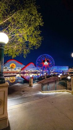 an amusement park at night with lights and rides