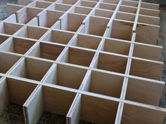 wooden drawers are lined up in rows on the floor, ready to be used as storage