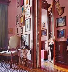 a room with pictures on the wall and a chair in front of an open door