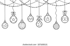 christmas balls hanging from a line with barbed wire on the top and bottom, in black and white