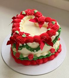 a decorated cake sitting on top of a white plate covered in frosting and bows