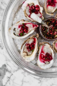 several oysters on an ice platter with red sauce and garnishes