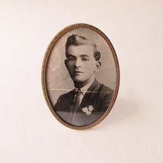 an old photo of a young man wearing a suit and tie with a flower in his lapel