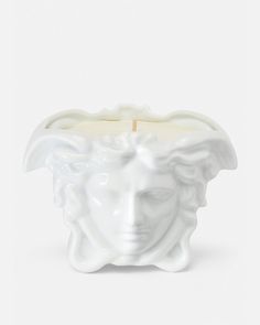 a white candle with a face on it