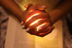 a woman is holding her hands with glowing light