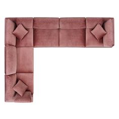 a large pink couch with pillows on it's back and side facing the wall