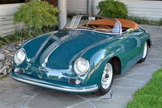 a green sports car parked in front of a house with a tan leather seat cover