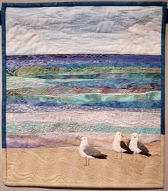 two seagulls are standing on the beach