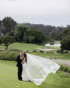 a bride and groom kissing on the golf course