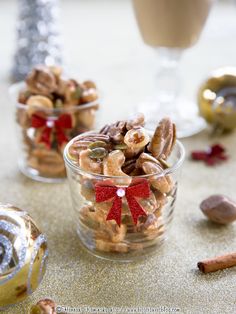 two small glass bowls filled with nuts and cinnamons next to a christmas ornament