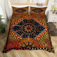 a bed covered in a colorful comforter next to a wooden floor with plants on it