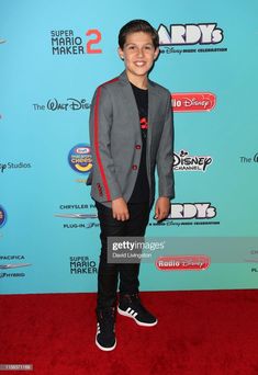 a young boy poses on the red carpet at disney studios's live - in - time