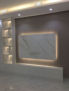 an empty room with white marble walls and shelves on the wall is lit by recessed lighting