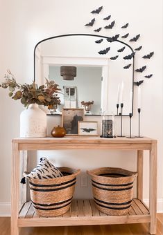 a wooden table topped with baskets under a mirror