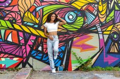 a woman standing in front of a colorful wall