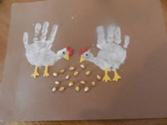 handprints made to look like chickens and corn on a brown piece of paper