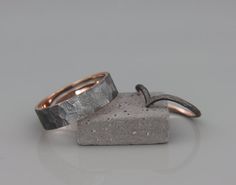 two rings sitting on top of each other in front of a gray background with small bubbles