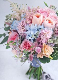 a bouquet of pink and blue flowers on a white background