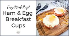 an egg and cheese breakfast cups on a wooden cutting board with fork and knife next to it