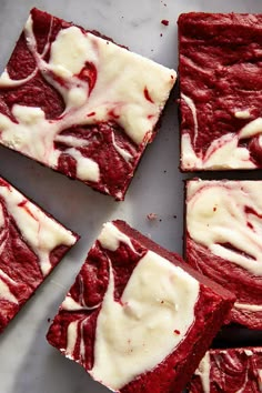 red velvet brownies with white icing on a marble counter top, cut into squares