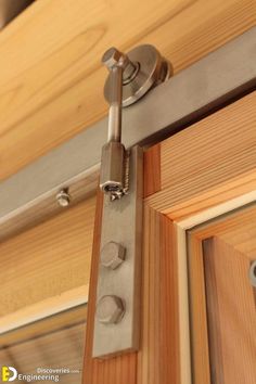 a close up of a door handle on a wooden door with metal bars and screws