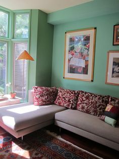 a living room filled with furniture and lots of pictures on the wall next to a window