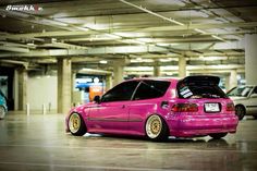 a pink car parked in a parking garage