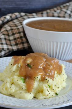 mashed potatoes covered in gravy on a white plate