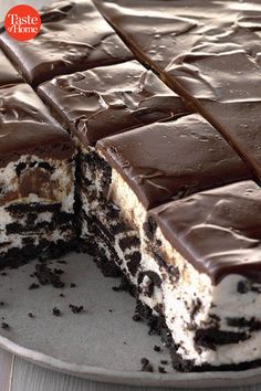 a cake with chocolate frosting and oreo cookies on top is cut in half