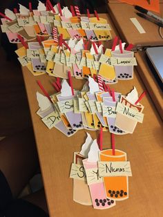 many small pieces of paper with name tags attached to them sitting on a table next to a laptop