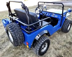 a blue golf cart is parked in the grass with wheels on it's side