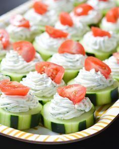 cucumber bites with cream cheese and tomatoes on them are ready to be eaten