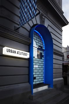 the entrance to an urban altitude building with a blue arch on it's side