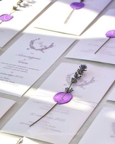 lavender flowers are placed on top of wedding cards