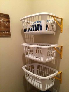 three laundry baskets stacked on top of each other in the corner of a bathroom stall