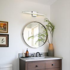 a bathroom with a toilet, sink and mirror