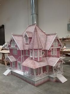 a large pink doll house sitting on top of a table