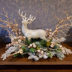 a white deer with antlers and flowers on a table