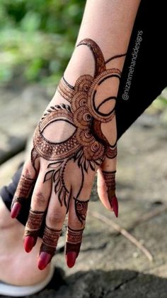 a woman's hand with henna tattoos on it