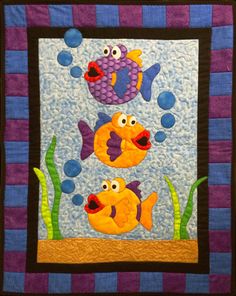 a quilted wall hanging with fish and bubbles on it