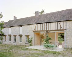 an old house with a table and chairs outside