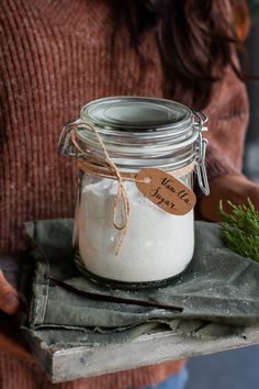 a person holding a glass jar with some white stuff in it