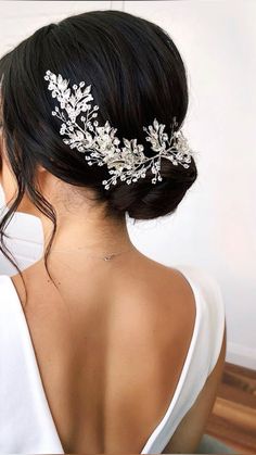 a woman wearing a bridal hair comb with leaves on it's back and side