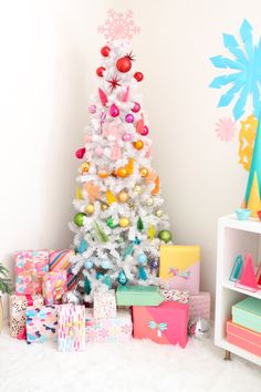 a white christmas tree surrounded by presents